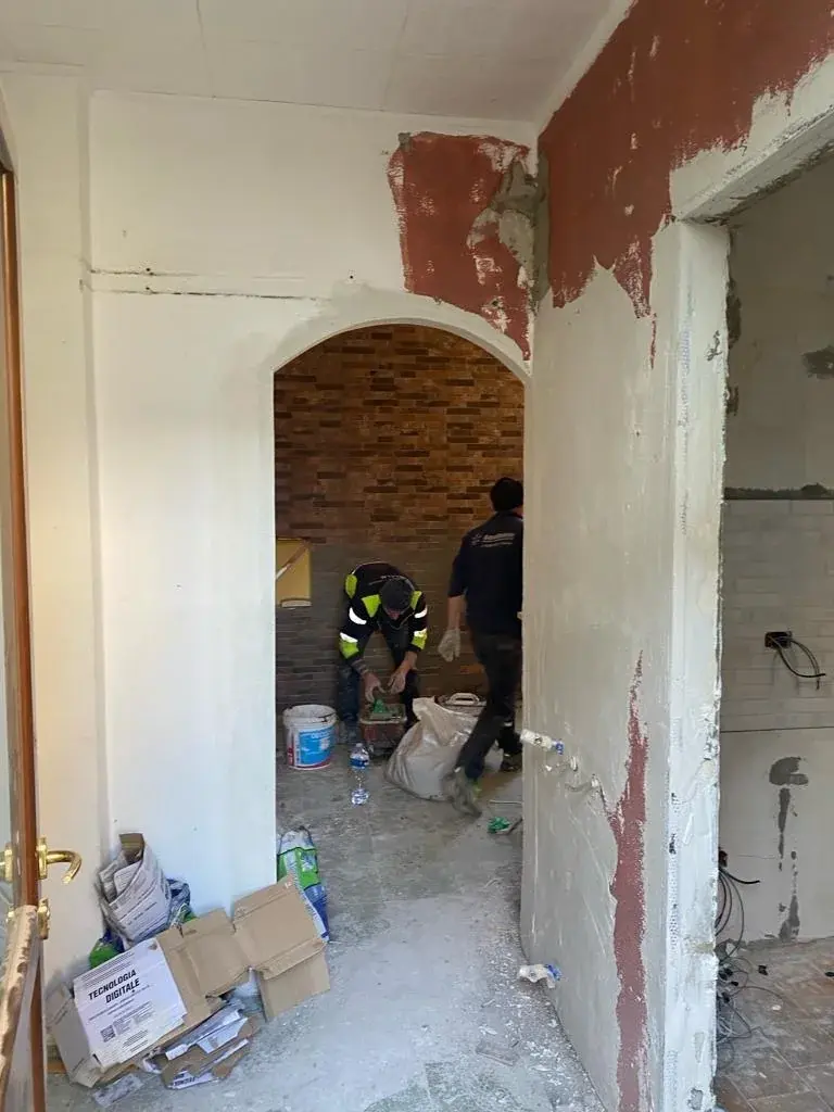 הדירה בברגמו בזמן השיפוץ: קשת בקיר, קירות חשופים ובעלי מקצוע בעבודה